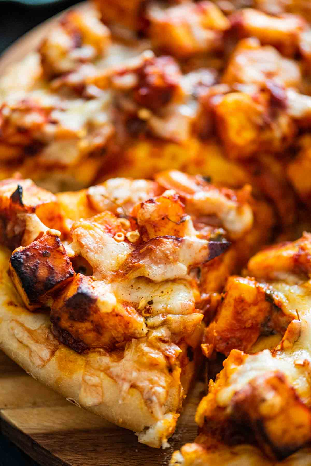 close of pizza slice with paneer topping