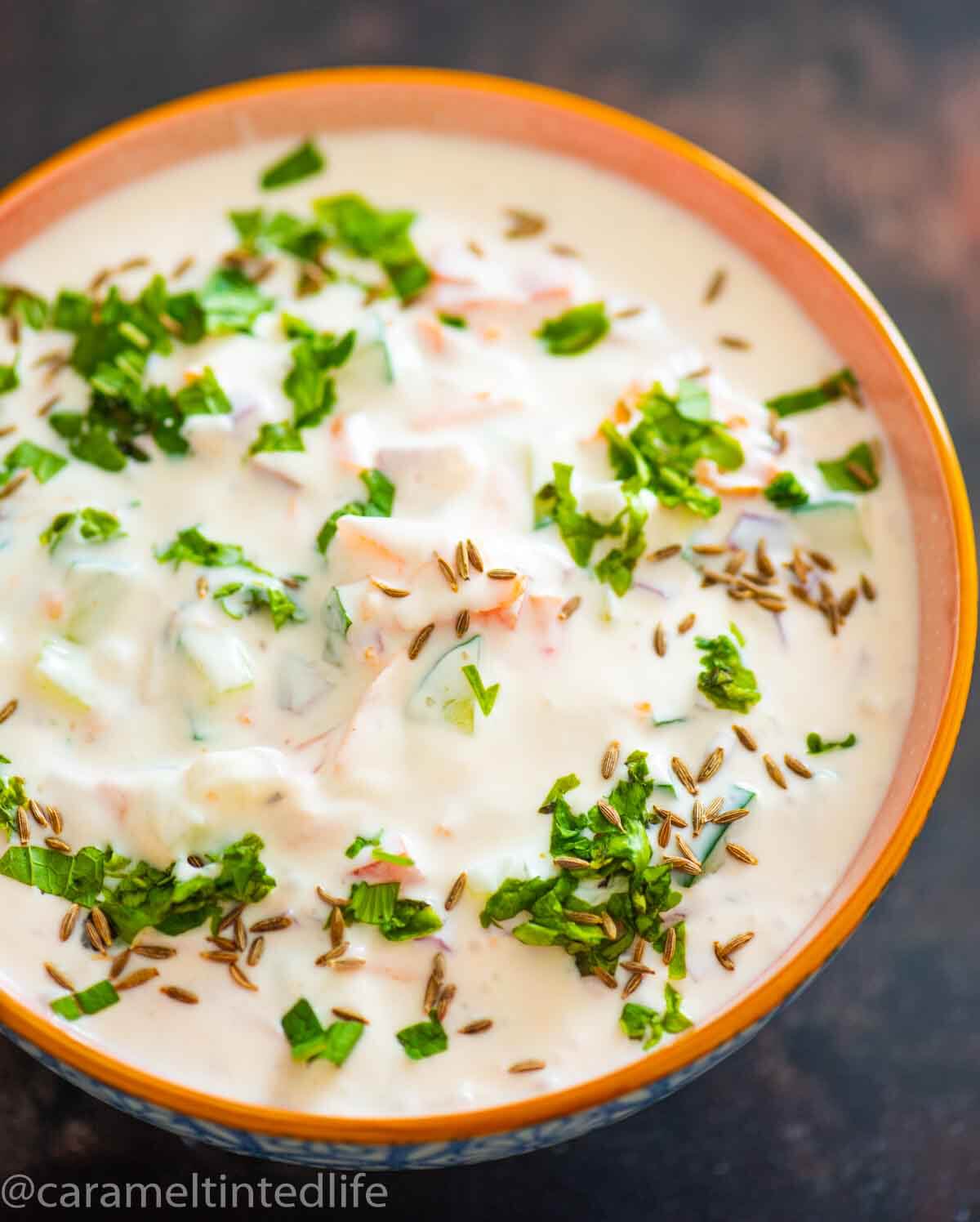 bowl of raita with cilantro cumin garnish 