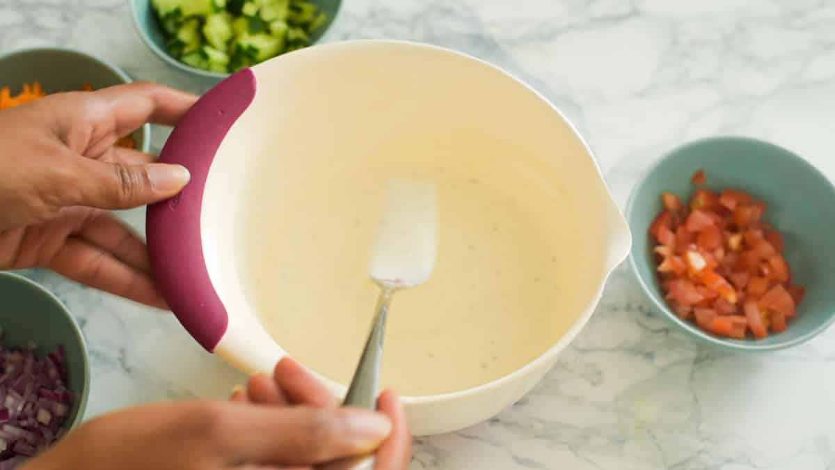 hand using fork to whip a mixing bowl of yogurt