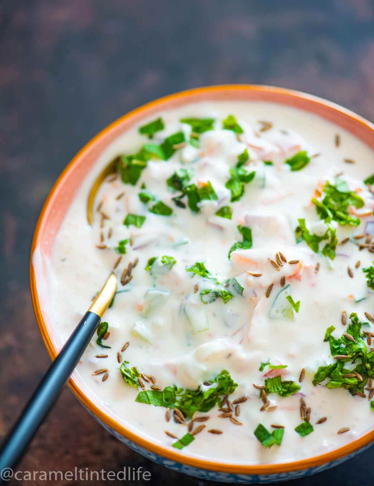 bowl with yogurt raita and spoon