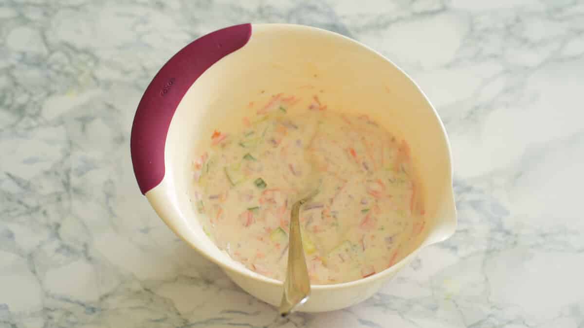 mixing bowl of yogurt mixed with veggies 