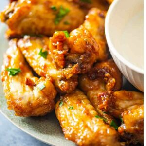 side view of chicken wings on a plate with dip