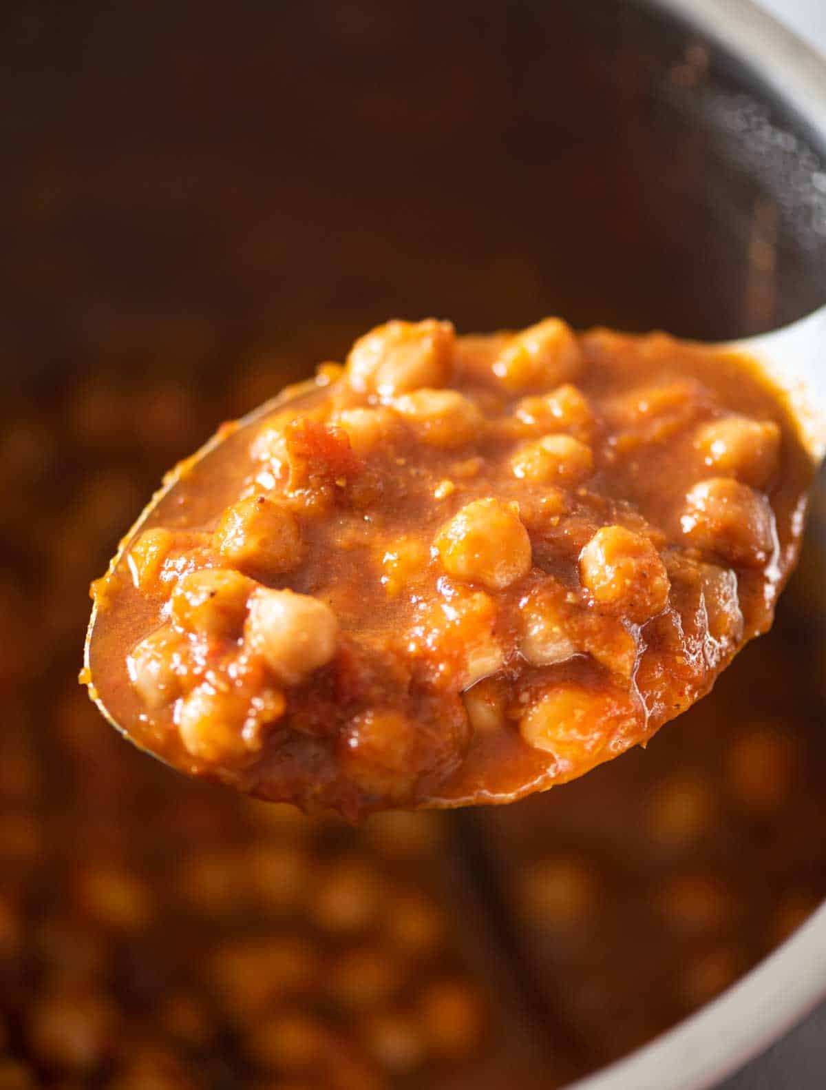 ladle with chickpea masala over an instant pot