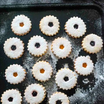 linzer cookies on a black baking tray