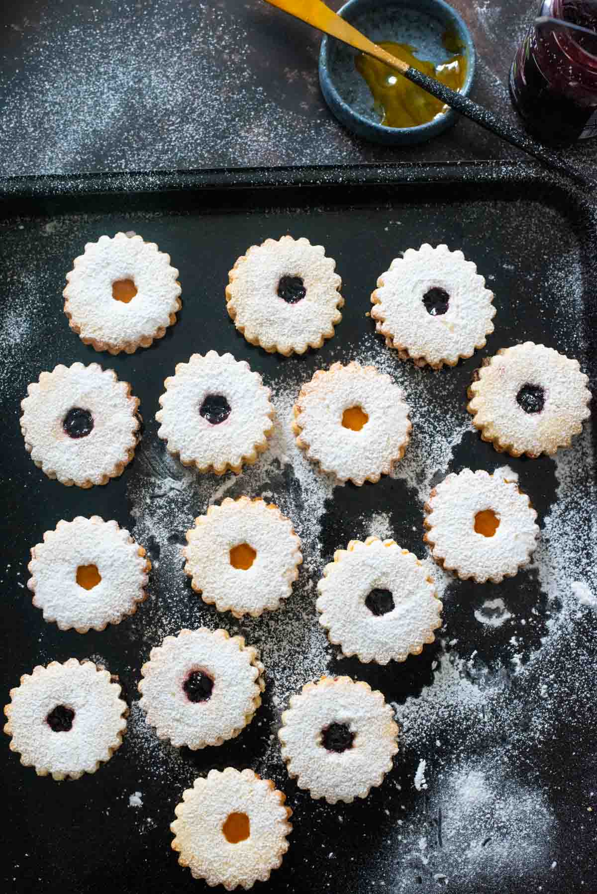 linzer cookies on a black baking tray