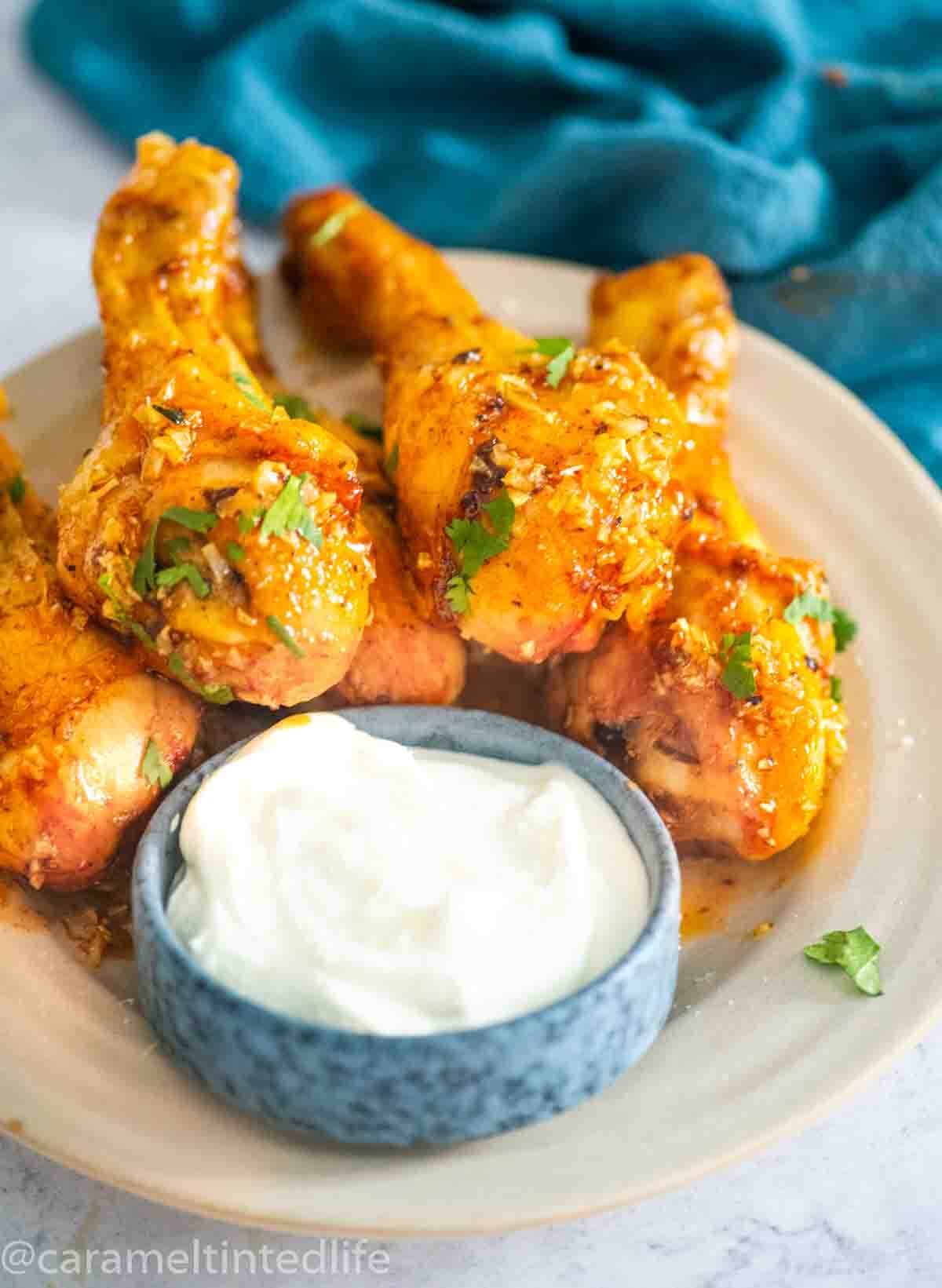 chicken legs in glaze on a plate with dip