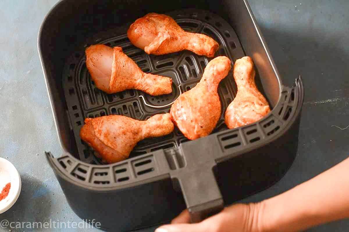raw marinated chicken legs in air fryer basket
