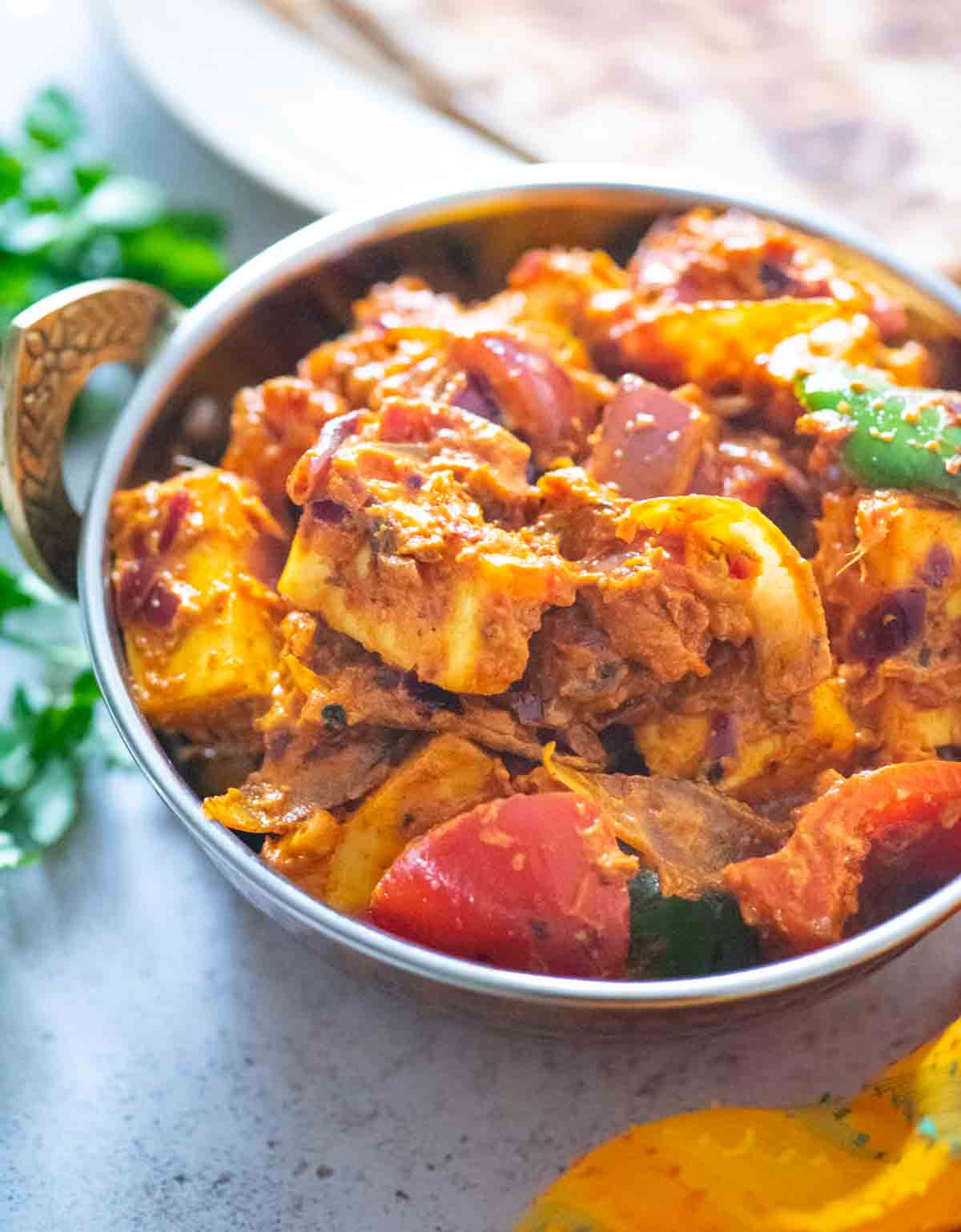 side view of kadai paneer in a serving bowl