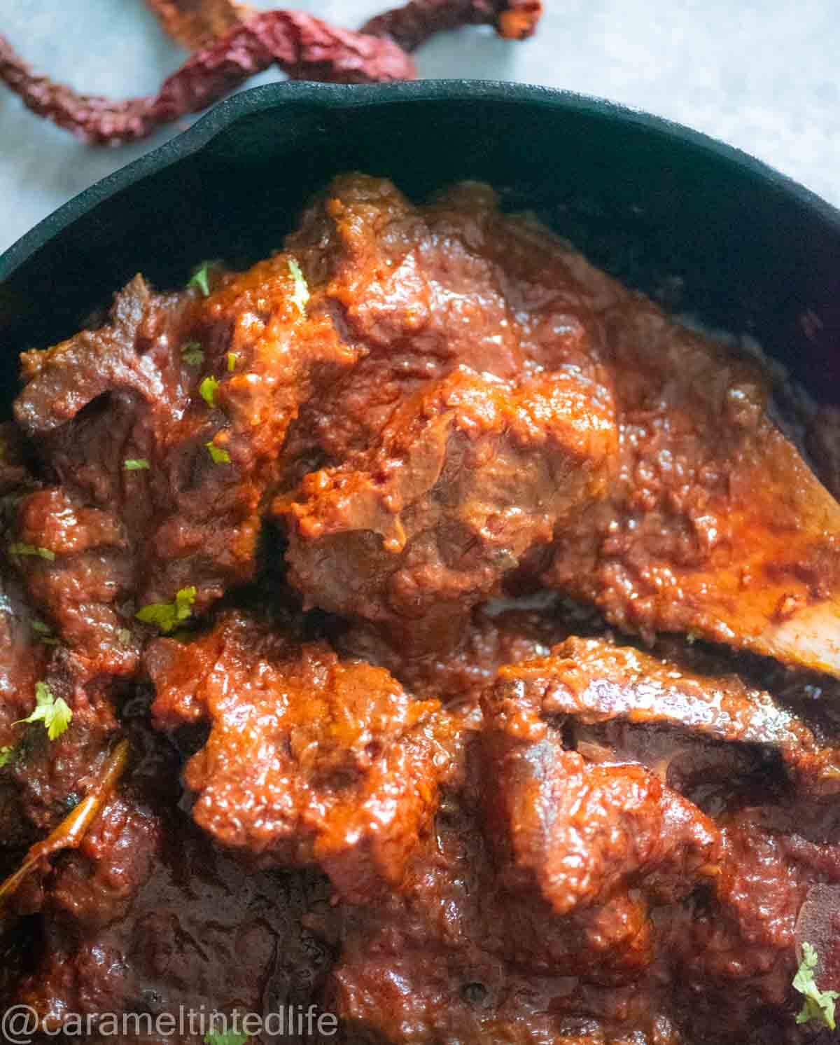 red mutton curry in black cast iron pan