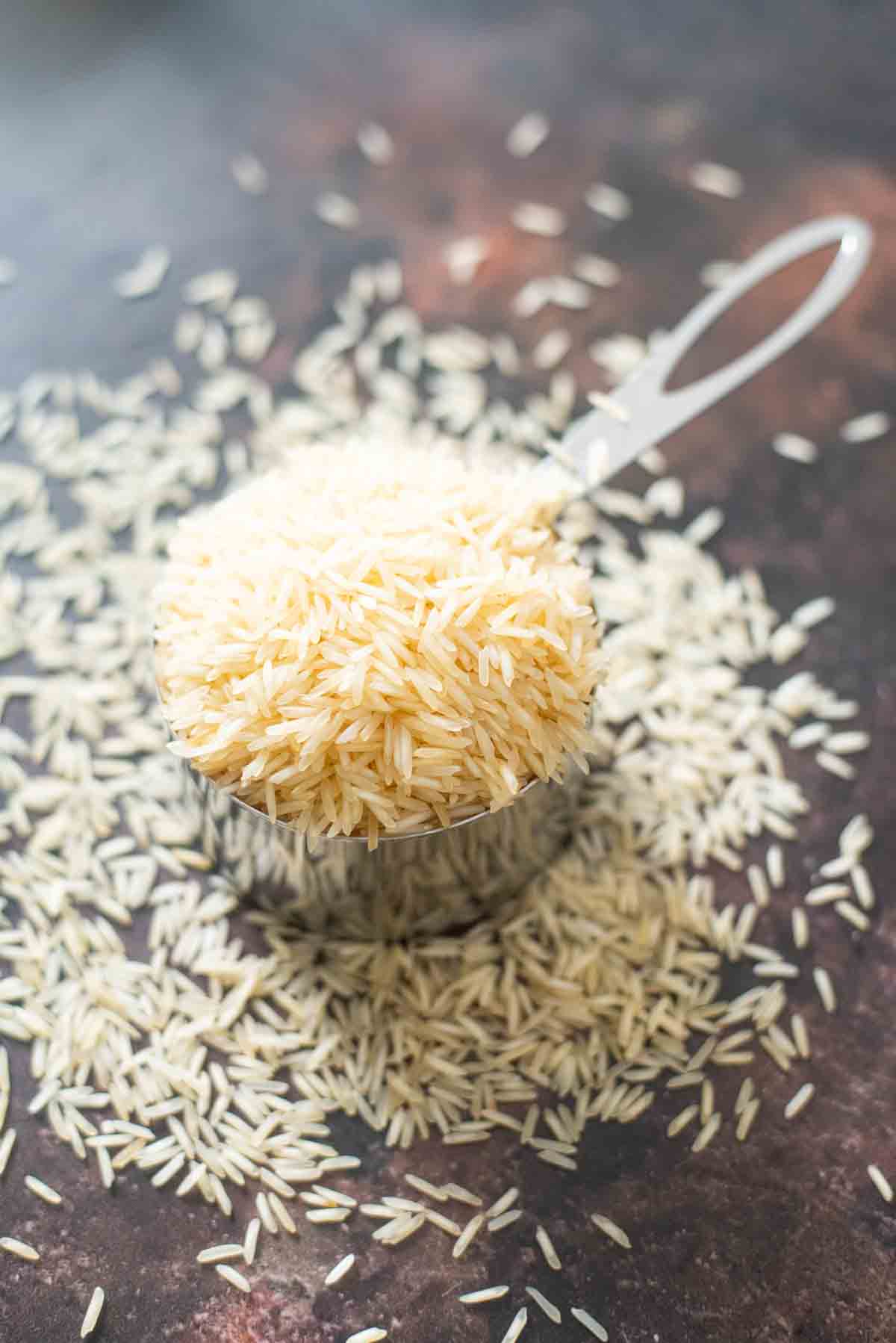 raw rice spilling out of a measuring cup