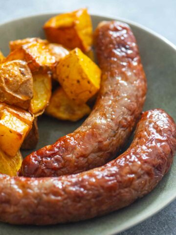 sausages with roated potatoes on a plate