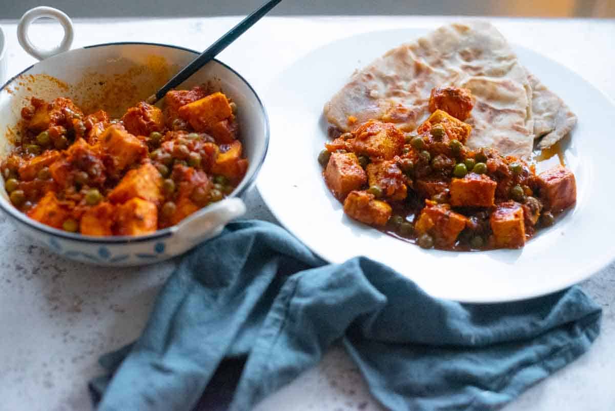 plate of matar paneer roti next to a bowl of matar paneer 